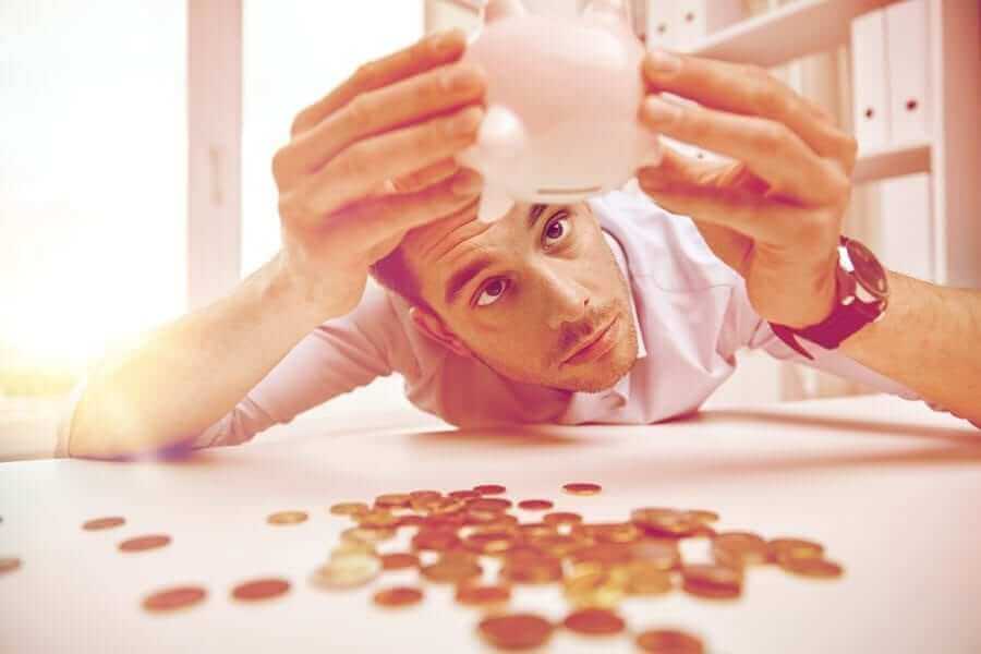 Man emptying out pennies from piggy bank