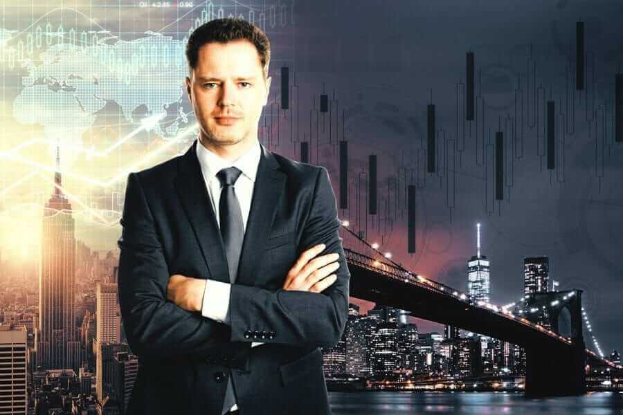 Business Man smiling with arms crossed in front of city scape with multiple graphics overlayed