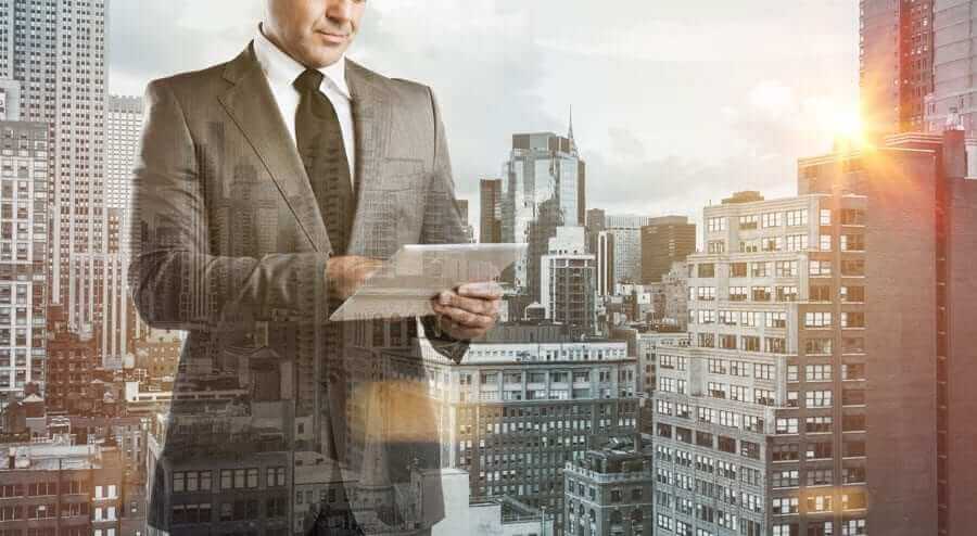 Business Man on tablet overlayed over cityscape