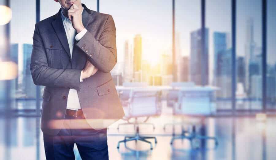 Thinking Business Man inside office building with city in window background