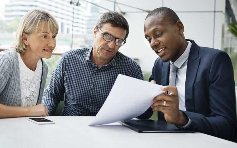 Business Man going over paperwork to elderly couple