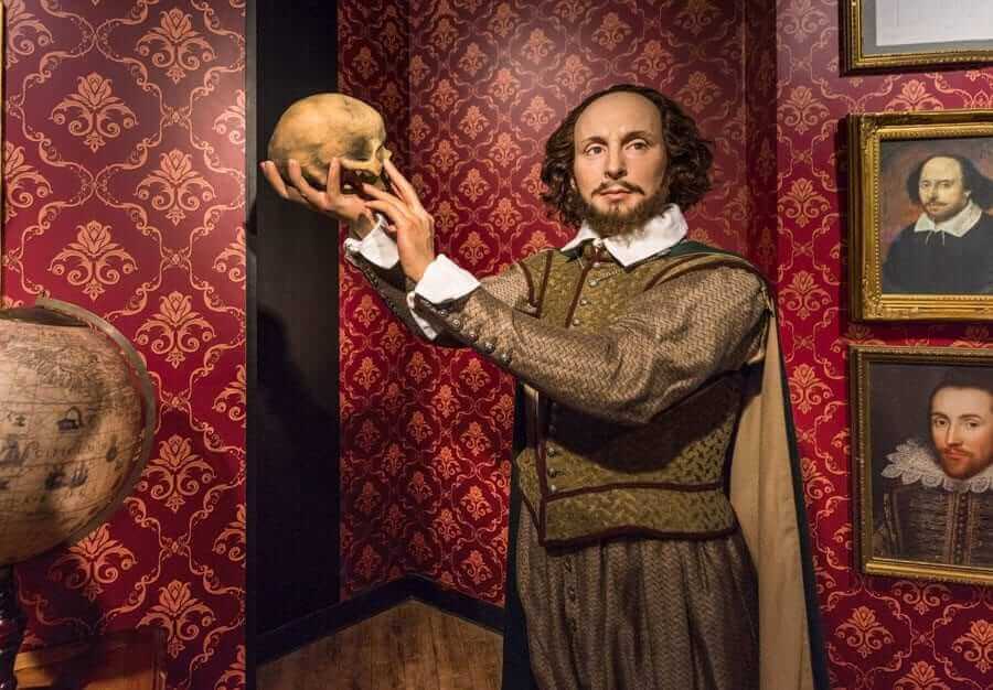 Man in classical costume holding up a skull
