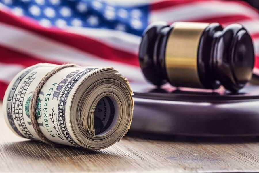 Roll of American dollars in front of Gavel and American Flag