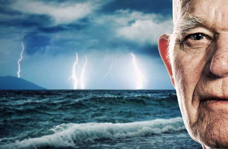 Half of man's face in front of ocean storm