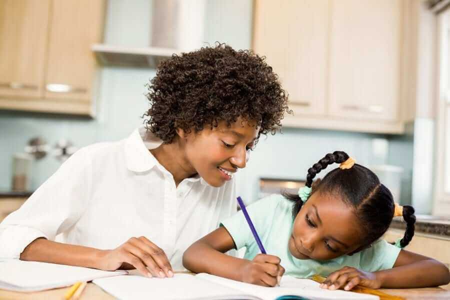 Parent helping young daughter with homework