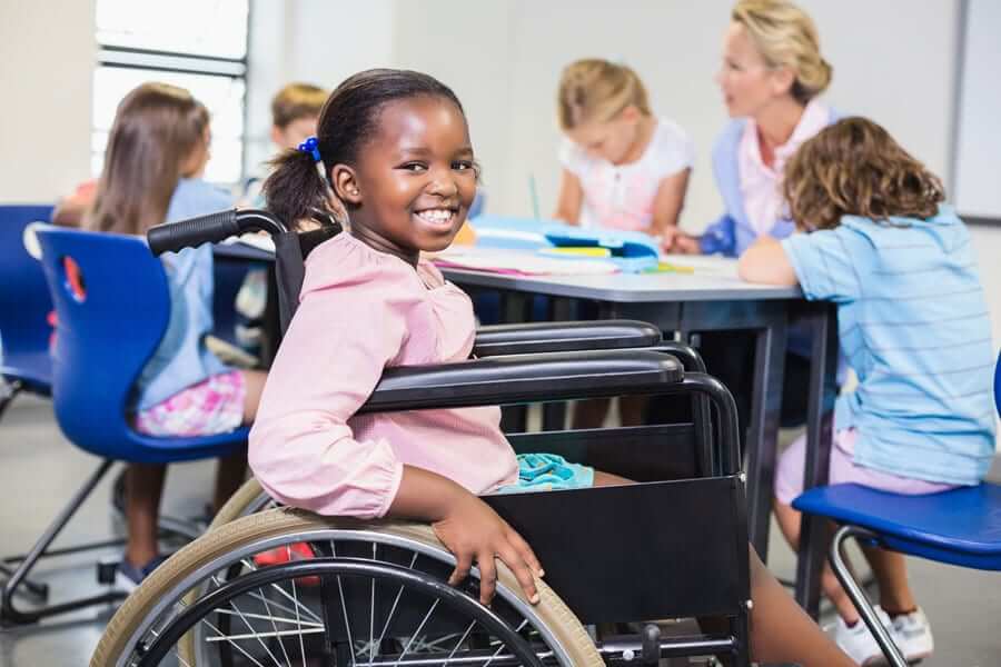 smiling girl in wheelchair at school