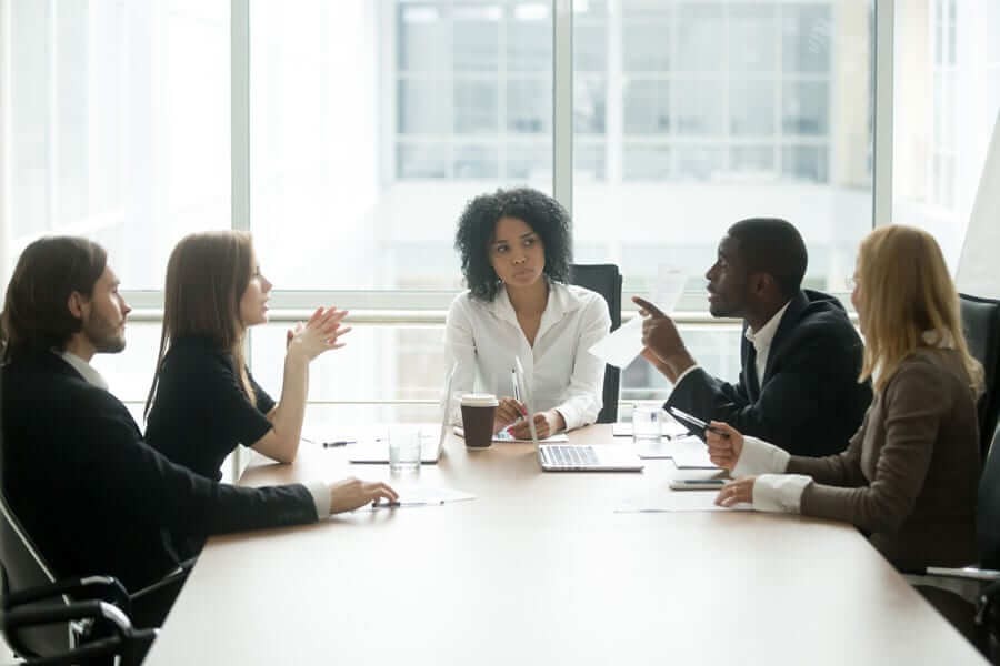 Business people arguing in meeting with frustrated business woman in the center
