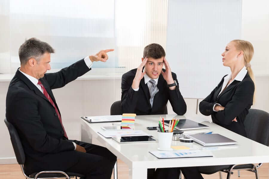 Business people arguing in meeting with frustrated business man in the center